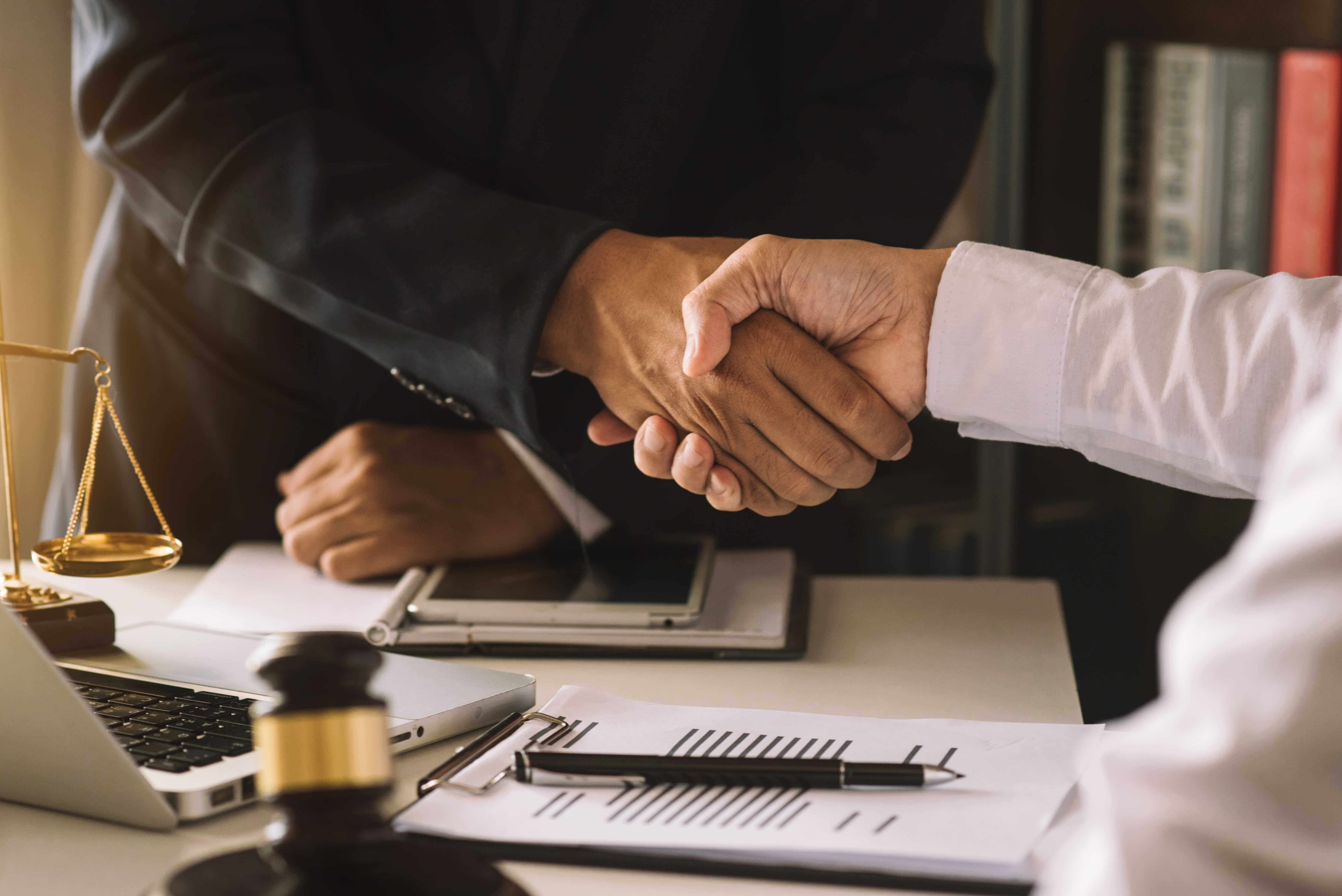 Business man and a lawyer shaking hands in an office